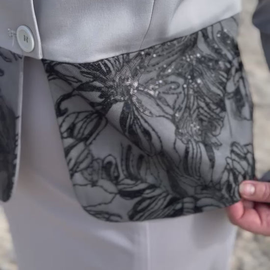 Close up on details on light grey and black dog show suit. Sapphire by Canis Certo.