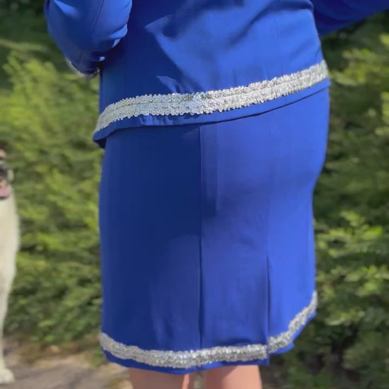 Woman wearing a royal blue dog show suit with sequin details in stretchy material. Celestite by Canis Certo.