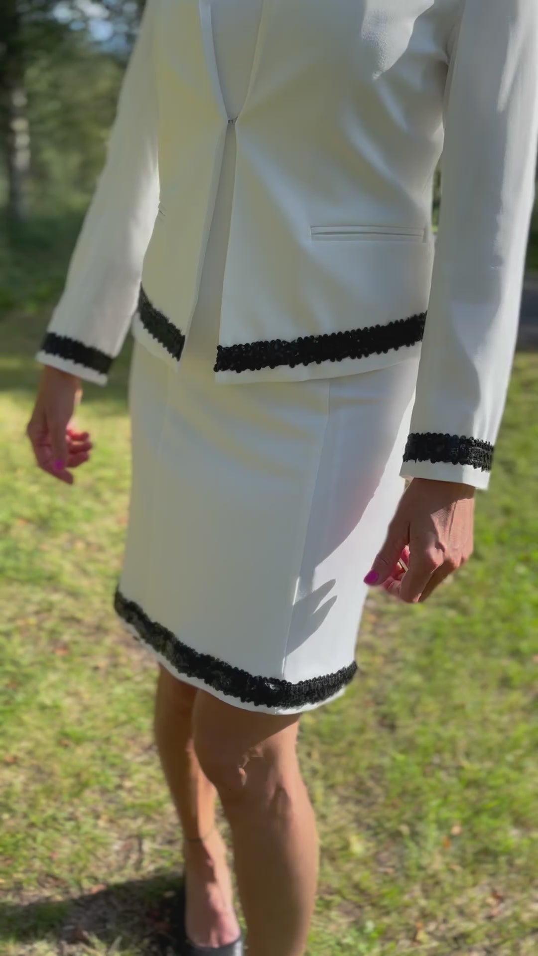 Dog handler wearing a white dog show suit with sequin details in stretchy fabric. Celestite by Canis Certo.